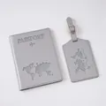Close-up of gray passport cover and luggage tag set with embossed world map and text - Gray
