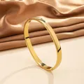 Detailed close-up of 18k gold-plated stainless steel bangle with polished mirror finish - 50# 6mm Curved Surface - Gold Sz615