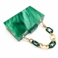 Détail d'une pochette de soirée en acrylique marbré vert avec bandoulière à chaîne - Motif de marbre vert avec chaîne épaisse en acrylique color-block