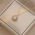 Detail view of purple sunflower pendant necklace with gold chain on a jewelry box lid - X4539-1