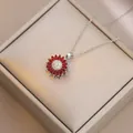 Macro detail of sunflower necklace with red petals and white crystals in a gift box - X4539-5