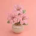 Handgefertigte gehäkelte Lilien-Topfpflanze mit rosa Blüten und Spitze auf rosa Grund - Rosa