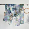 Detail of thin lightweight scarf featuring artistic leaf patterns and soft edging finish - Purple Blue Leaf