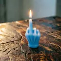 Close-up of a lit blue middle finger candle on a vintage wooden table background - Blue