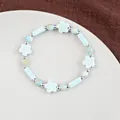 Light blue ceramic flower beaded bracelet with silver spacers on a ceramic plate - 1750-02 Cherry Blossom Encounter