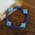 Ceramic beaded bracelet with navy beads and sky blue four-leaf clover charms on wood - 1734-02 Four-Leaf Clover