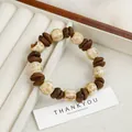 Ceramic beaded bracelet with coffee bean charms and cream spotted beads on display - Coffee White Bean Style (1689-02)