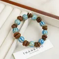 Blue ceramic beads and coffee bean charms on a bracelet inside a white gift box - Turquoise Blue Bean Style (1689-03)
