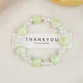 Pale green shell bead bracelet with iridescent white pearls on a cream fabric base - Green Shell Bead Style (1747-04) / Green Shell