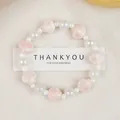 Ceramic beaded bracelet with pink shell charms and iridescent pearls on a white card - Pink Shell Phantom Style (1747-01) / Pink Shell