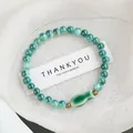 Handmade Jingdezhen ceramic beaded bracelet in turquoise with small fish charm and brass beads - Little Fish Style (1751-03) / Silent Green