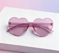 Pink jelly heart-shaped rimless sunglasses displayed on a white platform - Kids Heart Deep Pink