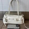 Off-white faux lederen baguette tas met metalen oogjes en een zilveren hart hanger - Wit