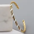 Macro detail of gold-plated twisted bangle with black and white enamel and zircons - White