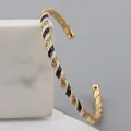 Adjustable golden twisted cuff bracelet with black and white enamel and zircon accents - Black