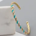Adjustable gold plated twisted bangle with blue enamel finish and white cubic zirconia - Lake Blue