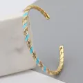 Adjustable gold plated twisted bangle with blue and white enamel and zircon accents - Sky Blue