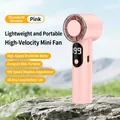Pink handheld mini fan with digital display placed on a grey rock with nature background - T361 Pink
