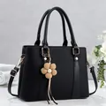 Minimalist large black PU leather tote bag with structured profile and floral charm - Black