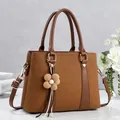 Brown textured patchwork tote bag with knit flower charm and adjustable shoulder strap - Brown