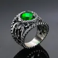 Close-up of gothic vintage men's ring with emerald green stone and dragon relief - Steel Oiled Green Gem