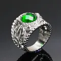 Macro shot of retro steel ring featuring emerald green gemstone and hollow carvings - Silver With Green Zircon
