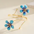 Close-up of vintage gold armlet with intricate blue enamel flower details - Blue
