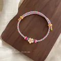 Handmade woven cord bracelet with white flower charm and adjustable gold accents - White Flower Pink Blue White Mixed Bracelet