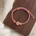 Handmade multicolor woven rope bracelet with pink lucky charm and gold finish details - Bracelet #6 - Red - Pink - Wealth From All Directions