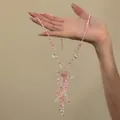 Detailaufnahme einer süßen rosa Blumen-Perlenkette mit zarten Quasten- und Kristalldetails - Choker-Halskette / Rosa
