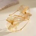 Macro view of gold metal open arm cuff with intricate filigree flower petals - Opening Style (HB5746) / Gold
