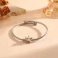 Detailopname van een zilveren kroonbedel van roestvrij staal op een gedraaide kabelarmband - Kroon Gedraaide Touwstijl (S709) / Staalkleur