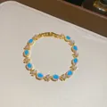 Eleganter goldener Armreif mit ovalem türkisfarbenem Harz und Kristallblumen - Ovales Blumenarmband (3#) / Gold-Blau