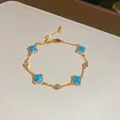 Detaillierte Nahaufnahme eines eleganten Gold-Blumenarmbands mit blauem Harz und Kristallen - Kleeblatt Armband (2#) / Gold-Blau