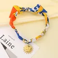 Bohemian retro silk scarf choker featuring a golden sun pendant on a yellow background. - Sun Pendant (KN297563-SXSJ) / Orange & Yellow Tones