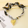 Choker in seta stampata stile boho vintage con pendente a cuore dorato strutturato - Nero e Giallo