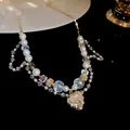 Primo piano di un'elegante collana in acciaio con perle di vetro e ciondolo a cuore di cristallo - 5# Collana-Oro