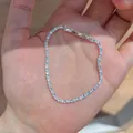 Close-up of a delicate silver tennis bracelet with lake blue and clear zircons - Round Clasp Bracelet / Silver-Blue