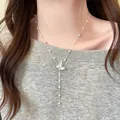 Detailansicht einer zarten Schmetterlingskette mit eleganten Perlen an einem Modell. - Silber