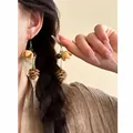 Close-up of Maillard style earrings with wooden pinecone and flower bud charms - Ear Hook Style Type 2