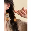 Detailed macro view of unique ethnic style Maillard wood fruit beaded fringe earrings. - Hook Style