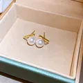 Elegante vergoldete Perlenohrstecker mit glänzenden Perlen und funkelnden Diamantakzenten - Einfacher Zirkonia-Perlen-Stil / Gold
