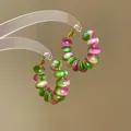 Close-up view of rainbow gradient beaded hoop earrings with vibrant green and pink resin beads - Silver Earring Post Earrings / Pink Green Gradient