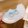 Primo piano di eleganti orecchini a lobo con zirconi acquamarina e perle a farfalla - 32# Ago d'Argento - Argento Blu