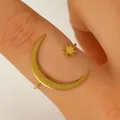 Detailansicht eines goldenen Edelstahlrings mit Halbmond und Stern an einem Finger - Offener Ring (A-1102) / Titangold Farbe