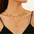 Collana doppia dorata a tema marino con ciondoli a stella marina e perle su modella - Stile Perla Stella Marina Conchiglia Oro (5749)