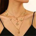 Collana multistrato dorata con stelle marine, conchiglie e perle su una modella - Stile Delfino Conchiglia a Tre Strati Oro (7215)
