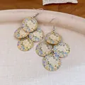 Close-up detail of vintage floral print round tassel drop earrings with enamel finish - Blue-White
