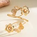 Elegant golden spiral arm cuff featuring exquisite butterfly and pearl flower details - Gold