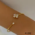 Elegant gold-plated stainless steel open bangle with sparkling heart crystal clover charm - Four-Heart Rhinestone Clover Style (A1292) / Gold